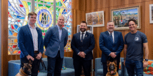 Group of five men with two assistance dogs at an RSL WA event.